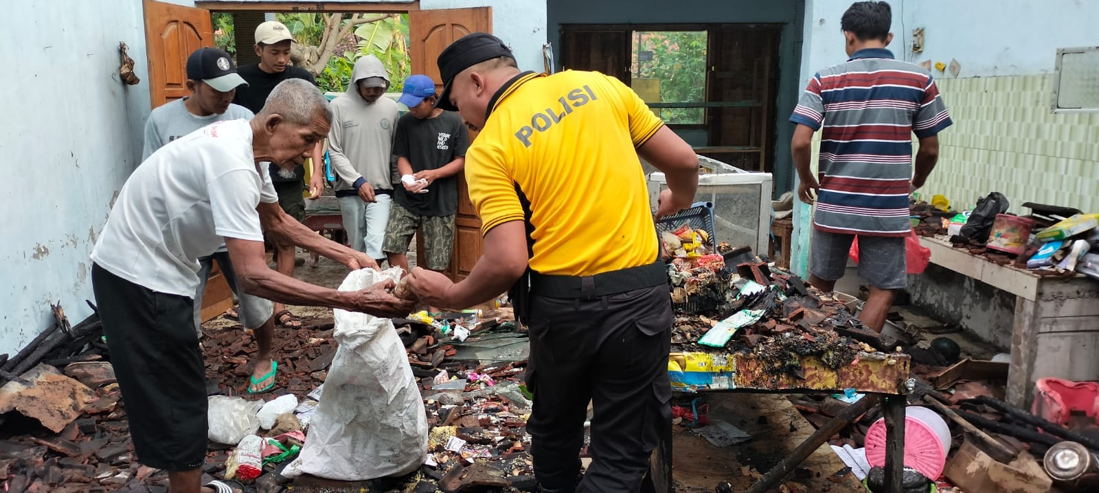 Bhabinkamtibmas Polsek Nganjuk Kota Kerja Bakti Bersama Warga Bersihkan Puing Kebakaran