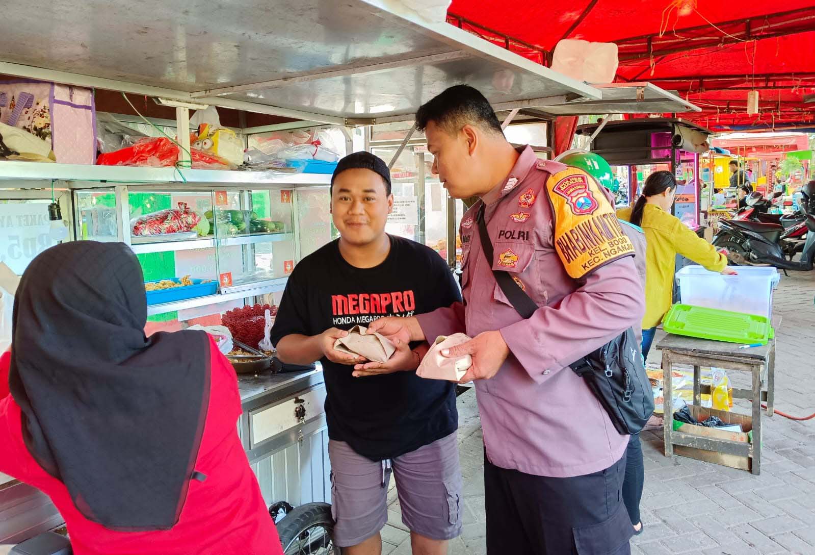 Anggota Polsek Nganjuk Kota Bagikan Nasi Bungkus Gratis Kepada Warga dan PKL di Seputaran Alun-alun Nganjuk