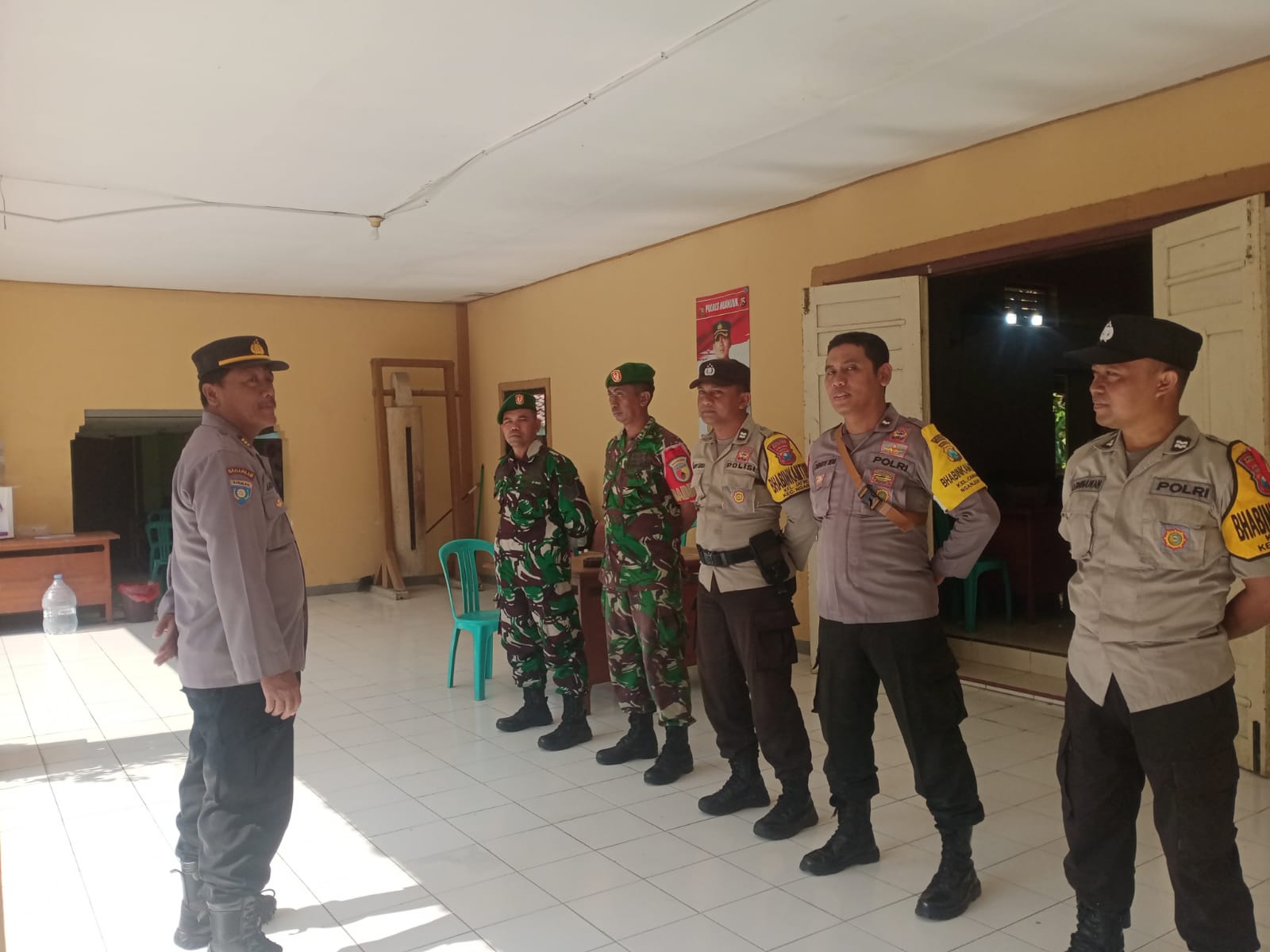 Personel Polsek Nganjuk Kota Bersama Koramil Pantau Pelaksanaan Rapat Pleno Rekapitulasi Penghitungan Perolehan Suara Pemilu 2024 di Gudang Logistik PPK Nganjuk