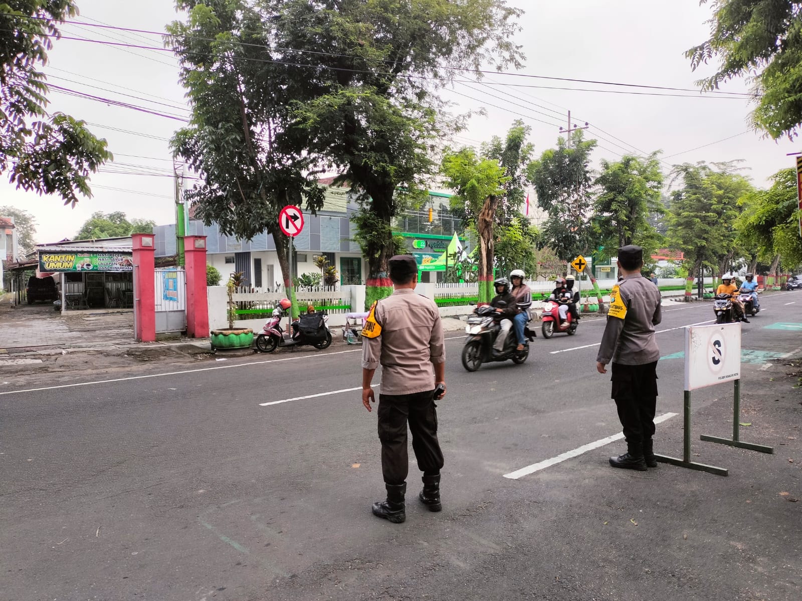 Personel Polsek Nganjuk Kota Lakukan Penyebrangan Masyarakat dan Pantau Arus Lalu Lintas