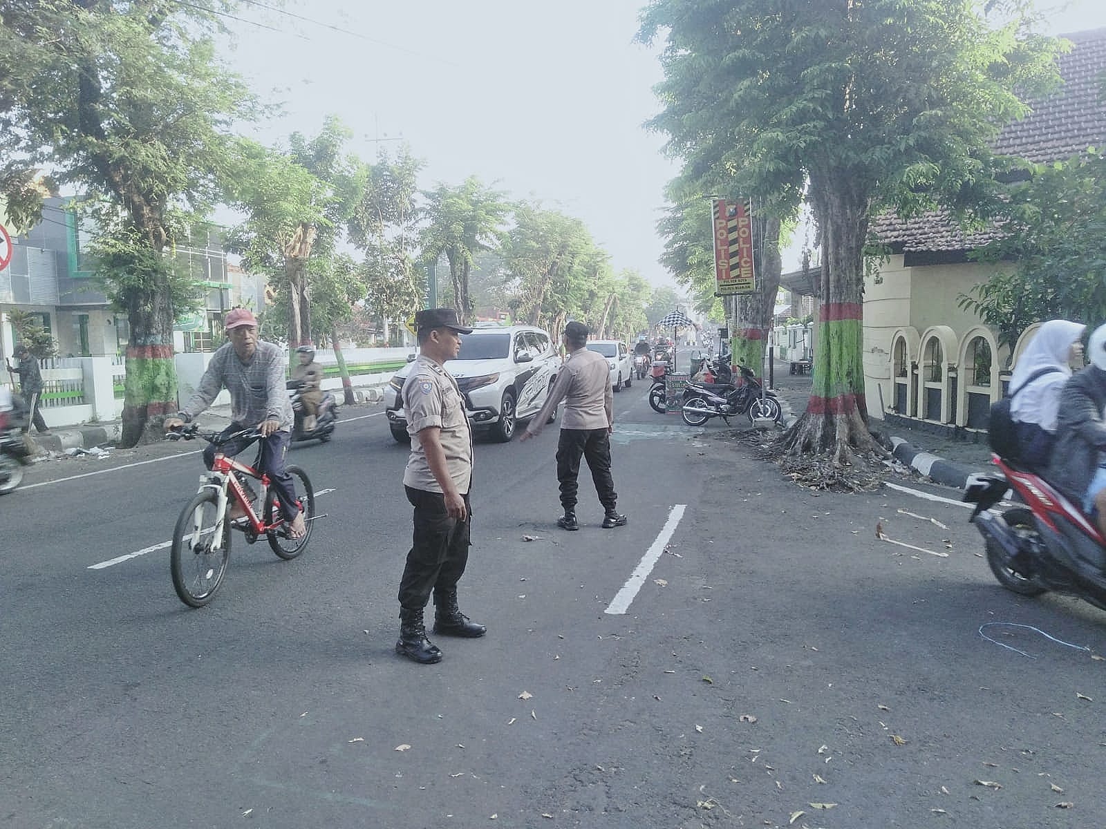 Giat Penampilan Pagi Anggota Polsek Nganjuk Kota Bantu Penyebrangan Masyarakat Beraktivitas di Pagi Hari