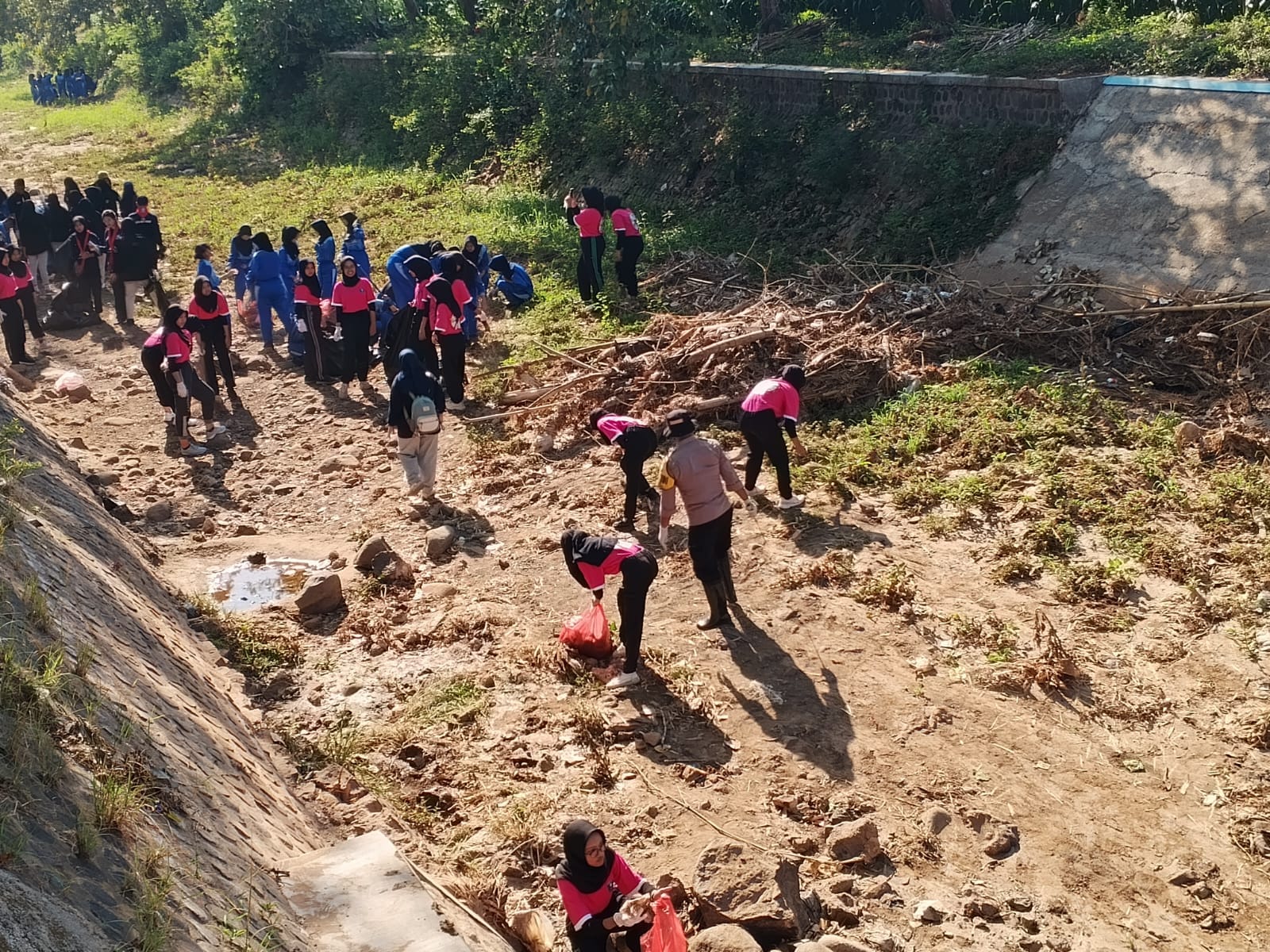 Bhabinkamtibmas Polsek Nganjuk Kota Bersama 3 Pilar dan Siswa SMA N 2 Nganjuk Gelar Aksi Bersih Kali Ploso untuk Antisipasi Banjir