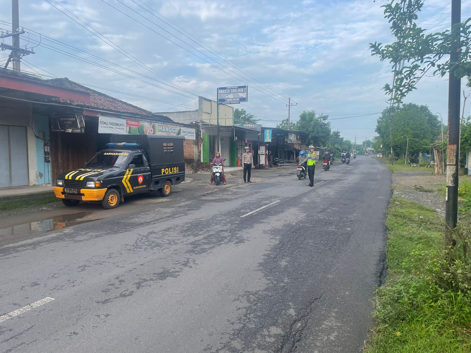 Anggota Polsek Warujayeng Bantu Penyeberangan Anak Sekolah di Pagi Hari