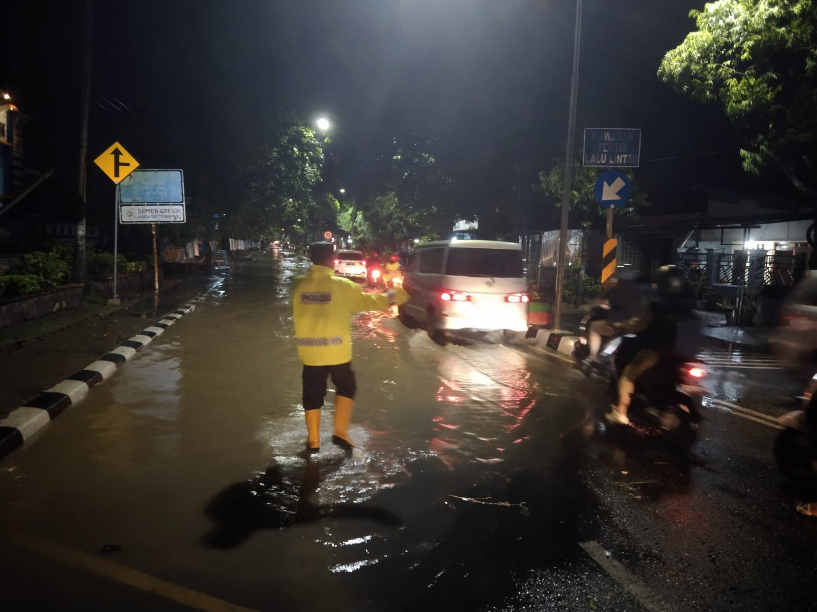 Aksi Cepat Tanggap Bhabinkamtibmas Polsek Nganjuk Kota Atur Lalu Lintas Akibat Genangan Air