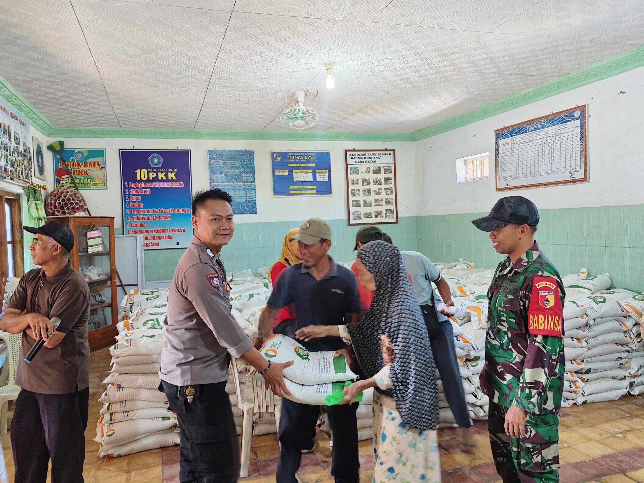 Bhabinkamtibmas Getas Polsek Warujayeng Dampingi Pembagian Bantuan Pangan Beras di Desa Binaannya