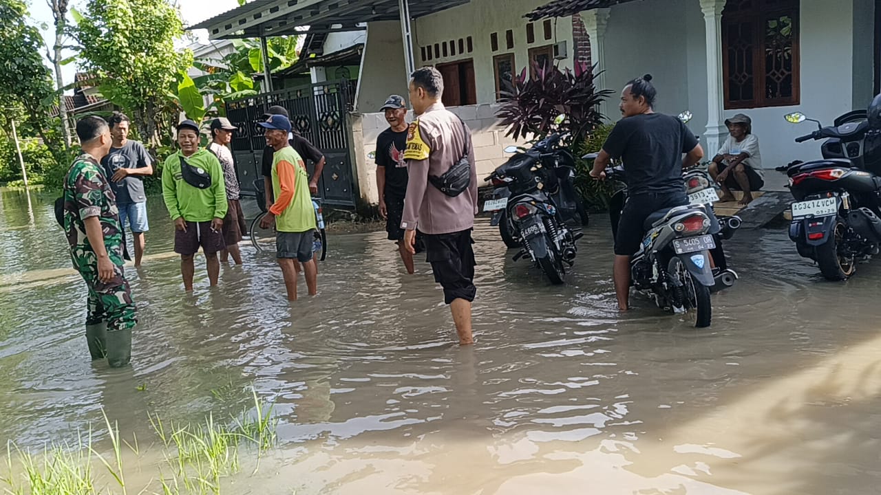Upaya Bhabinkamtibmas Jogomerto Bersama Tiga Pilar Tindaklanjuti Genangan Air Pasca Hujan Deras di Desa Binaannya