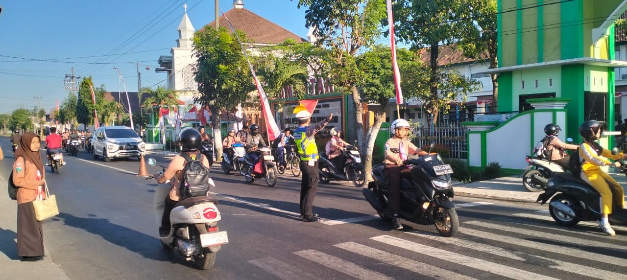 Wujud Melayani Masyarakat, Personel Polsek Warujayeng Bantu Penyeberangan dan Atur Lalu Lintas di Depan SMAN 1 Tanjunganom